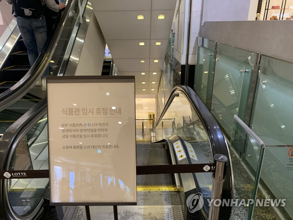A notice for the temporary closure of a department's supermarket in downtown Seoul due to COVID-19 informs people next to an escalator leading to the store on May 5, 2021. (Yonhap)