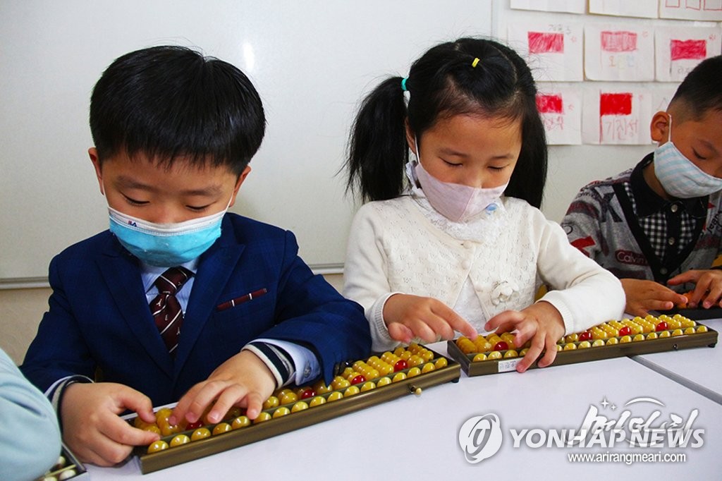 North Korean kids wearing face masks learn how to use an abacus during a class at a preschool in Pyongyang as the North has resumed in-person classes at schools amid the coronavirus pandemic, in this undated file photo captured from the website of North Korean propaganda outlet Meari on May 6, 2021. (PHOTO NOT FOR SALE) (Yonhap)