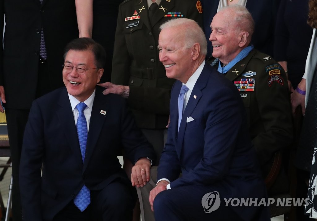 South Korean President Moon Jae-in (L) and U.S. President Joe Biden (R) pose for a group photo with 94-year-old retired Army colonel Ralph Puckett, Jr. (rear) and his family members in the East Room of the White House in Washington on May 21, 2021, during a ceremony to present him with the Medal of Honor for conspicuous gallantry in the 1950-53 Korean War. (Yonhap)