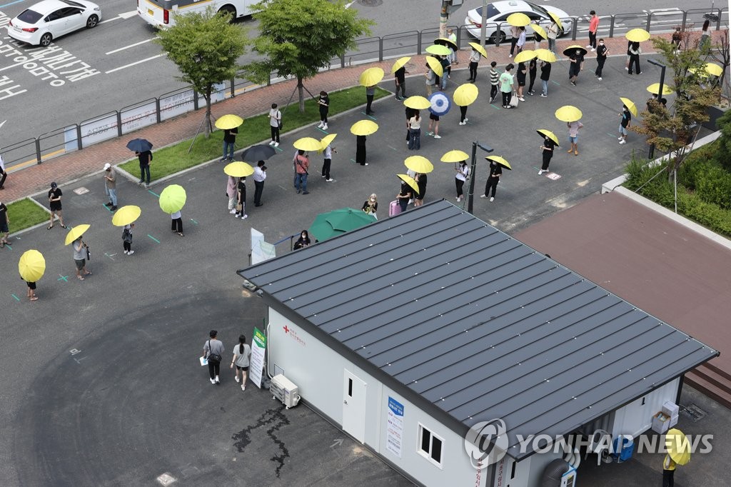 폭염 속 우산 쓰고 코로나 검사 대기하는 시민들