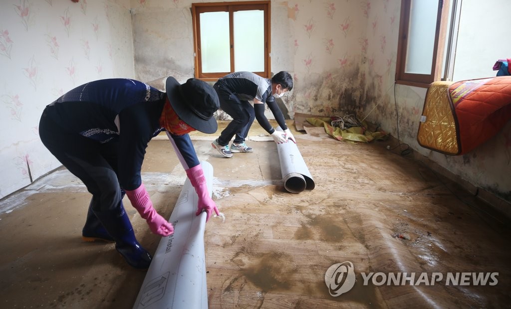 젖은 장판 걷어내는 봉사자들