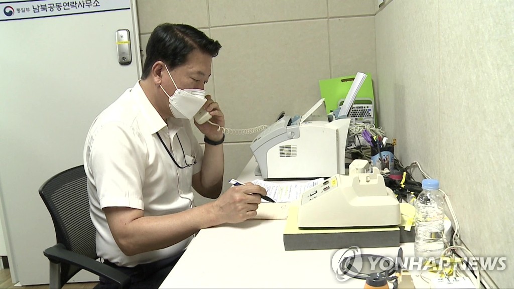 This undated file photo, provided by South Korea's unification ministry, shows a government official making daily contact via an inter-Korean liaison line. (PHOTO NOT FOR SALE) (Yonhap)