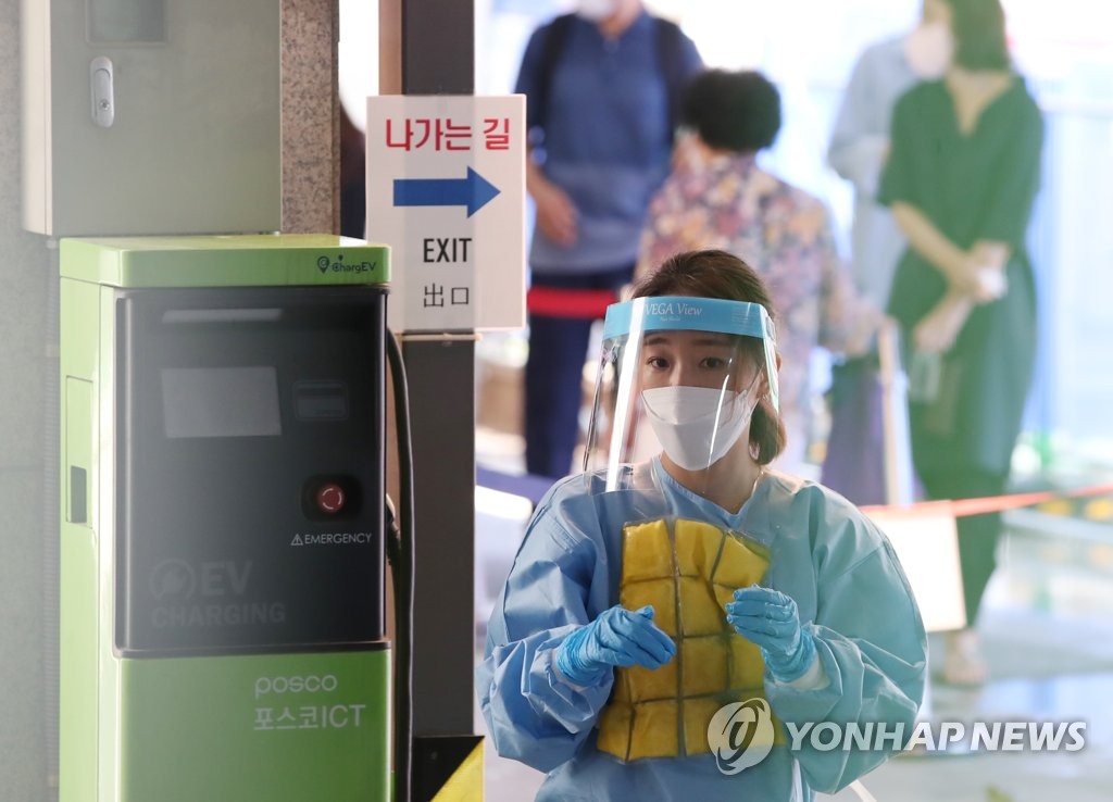 連日厳しい暑さが続く中、ソウル市内の保健所の医療関係者が保冷剤入りのチョッキを身につけて暑さをしのいでいる＝２８日、ソウル（聯合ニュース）