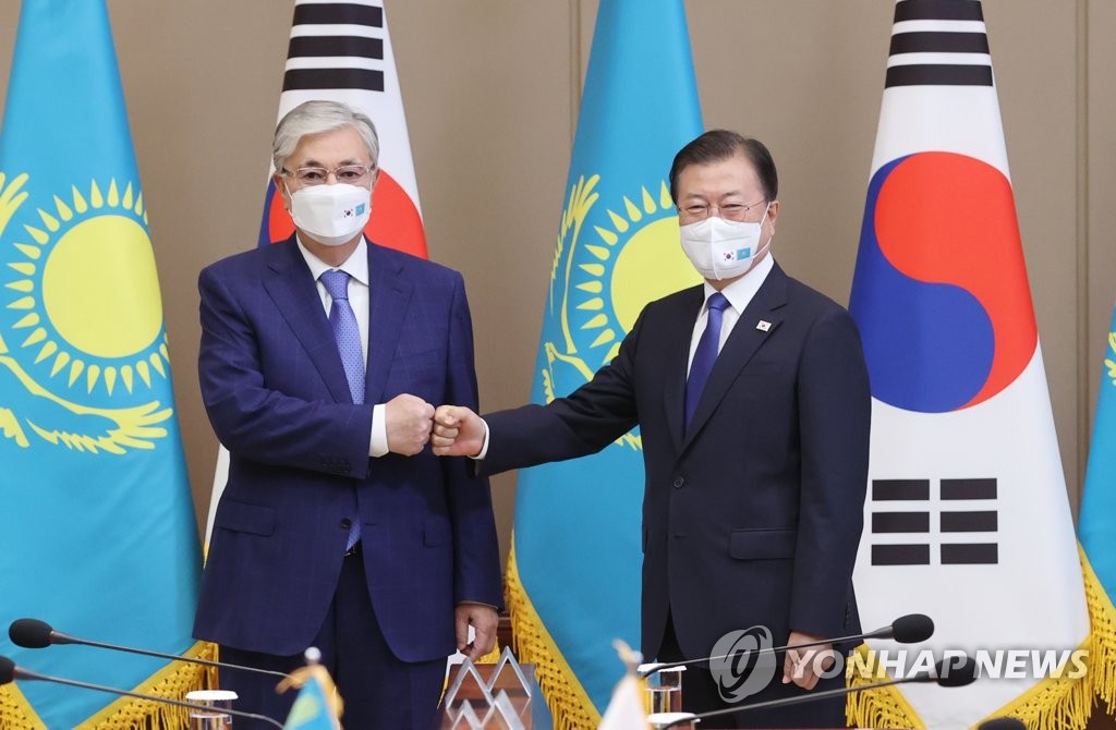 South Korean President Moon Jae-in (R) and Kazakh President Kassym-Jomart Tokayev bump fists ahead of their summit talks at Cheong Wa Dae in Seoul on Aug. 17, 2021. (Yonhap)