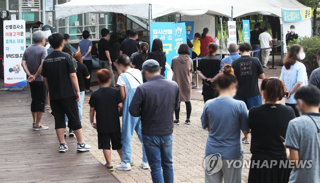 People stand in line to get COVID-19 tests at a temporary screening station at a highway rest stop in Yongin, south of Seoul, on Sept. 22, 2021, the last day of the Chuseok holiday. (Yonhap)