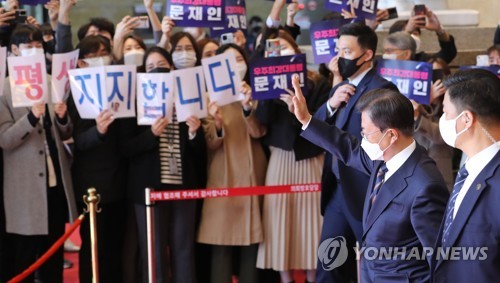 민주당 관계자들에게 손들어 답례하는 문재인 대통령