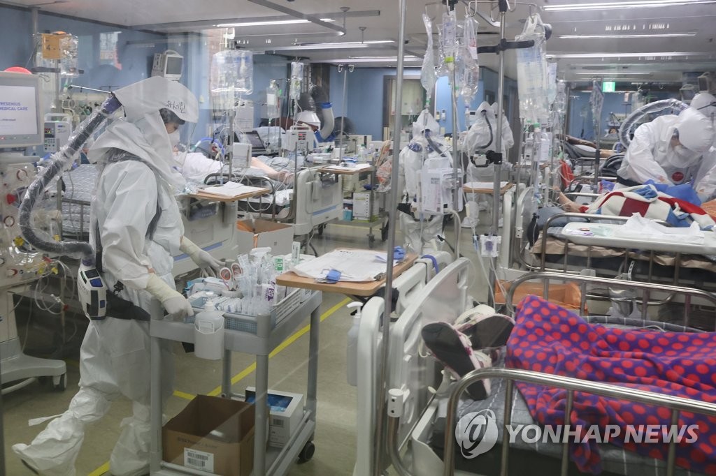 Medical workers in full protective gear care for COVID-19 patients at an intensive care unit of a COVID-only hospital in Pyeongtaek, 70 kilometers south of Seoul, on Nov. 23, 2021. The operating ratio of beds for critical patients in the metropolitan areas had reached 83.3 percent as of 5 p.m. the previous day, an all-time high. (Yonhap)
