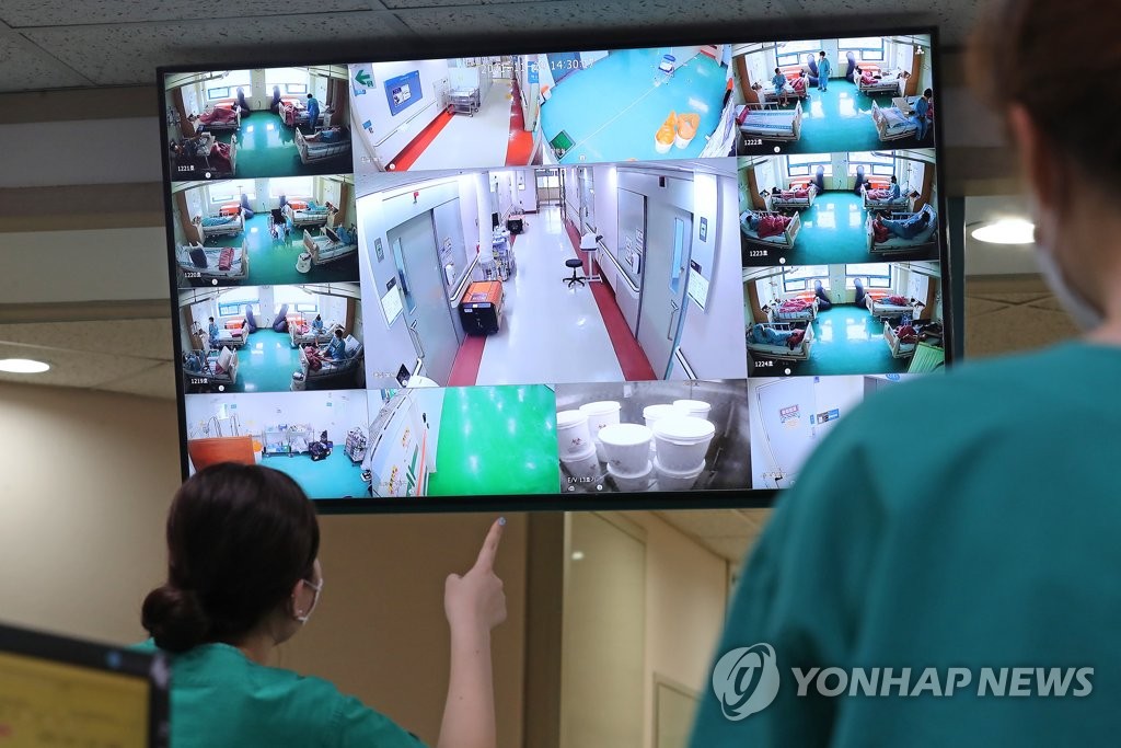 Medical workers look at a monitor showing the fully-occupied intensive care unit for COVID-19 patients of a university hospital in Daejeon, 164 kilometers south of Seoul, on Nov. 29, 2021, making the clinic no longer able to house more of such patients. (Yonhap)