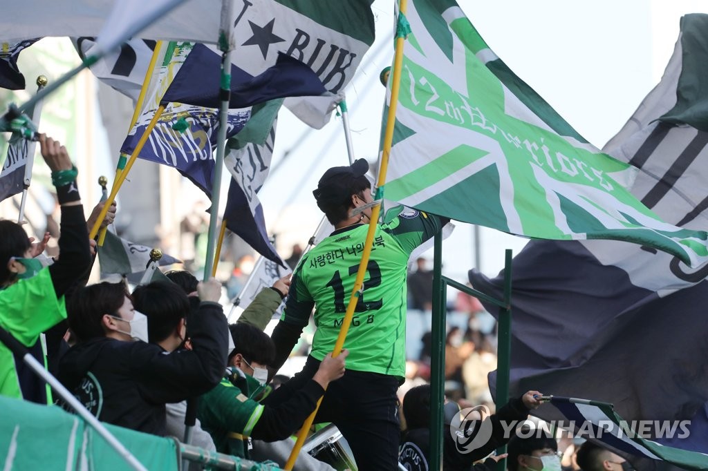 Supporters of Jeonbuk Hyundai Motors cheer on their club against Jeju United in a K League 1 match at Jeonju World Cup Stadium in Jeonju, some 240 kilometers south of Seoul, on Dec. 5, 2021. (Yonhap)