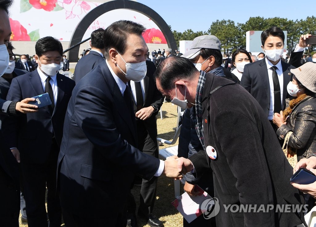 In this pool photo, President-elect Yoon Suk-yeol (L) shakes hands with a participant in a memorial service commemorating victims of a 1948 massacre in Jeju Island at Jeju April 3 Peace Park on the southern island on April 3, 2022. (Yonhap)