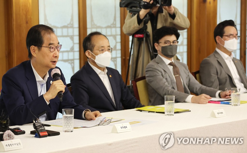 El primer ministro surcoreano, Han Duck-soo (izda.), habla en una reunión con los líderes del gobernante Partido del Poder del Pueblo y funcionarios presidenciales de alto rango, celebrada, el 25 de septiembre de 2022, en la oficina de Han, en Seúl.