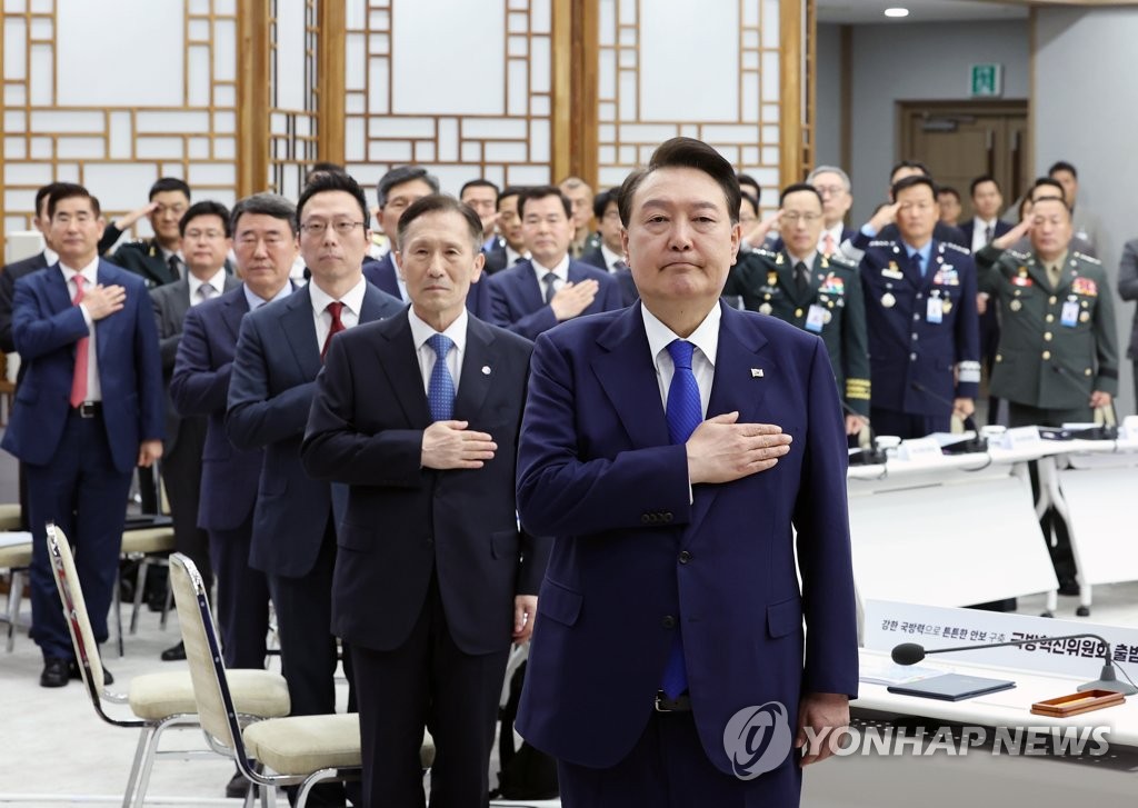 President Yoon Suk Yeol (front) salutes the national flag at the presidential office in Seoul on May 11, 2023, during a ceremony to launch the Defense Innovation Committee, headed by the president and tasked with guiding the implementation of new technologies and cybersecurity protocols in the armed forces. (Yonhap)