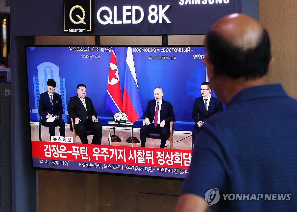 Una persona observa las noticias desde la Estación de Seúl, en el centro de la capital surcoreana, sobre la reunión entre el líder norcoreano, Kim Jong-un (segundo por la izda., en la pantalla), y el presidente ruso, Vladímir Putin (tercero por la izda., en la pantalla), el 13 de septiembre de 2023, en el cosmódromo de Vostochni, en la región rusa de Amur.