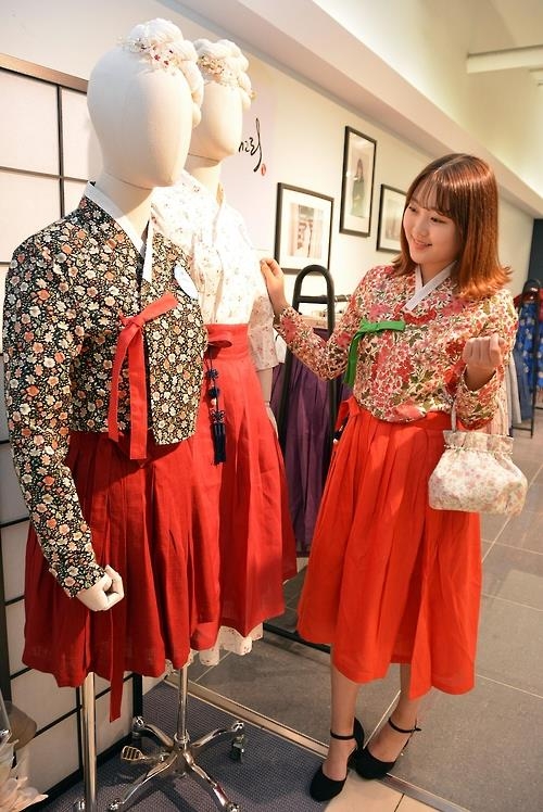 This undated photo provided by Daegu Department Store shows a woman checking out hanbok at a pop-up store in Daegu. (Yonhap)