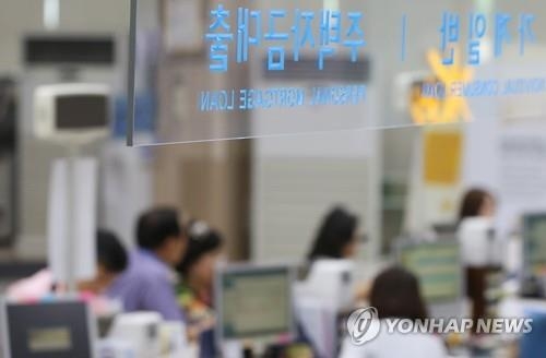 In this undated file photo, customers talk about mortgage loans with bank officials. (Yonhap)