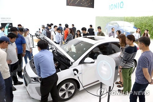 In this photo taken on June 6, 2016, a Hyundai Motor employee explains how the Ioniq all-electric vehicle works during the Busan International Motor Show held in the southern port city of Busan from June 3-12. (Yonhap)