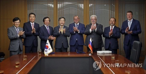 Park No-hwang (4th from L), president and CEO of South Korea's Yonhap News Agency, and Sergey Mikhaylov (4th from R), president of Tass, applaud after signing an agreement on the Russian news agency joining the PyeongChang News Service Network at the Yonhap headquarters in central Seoul on June 5, 2017. (Yonhap)