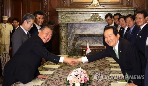 South Korea's National Assembly Speaker Chung Sye-kyun (R) and Japan's House of Representatives Speaker Tadamori Oshima shake hands at their meeting at the House of Representatives in Tokyo on June 8, 2017, in this photo provided by the parliament. (Yonhap)