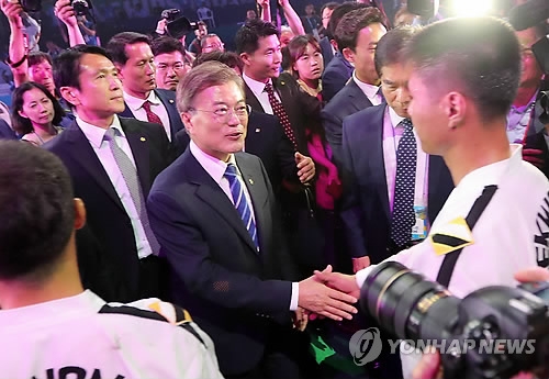 South Korean President Moon Jae-in (L) shakes hands with a North Korean taekwondo practitioner representing the International Taekwondo Federation (ITF) after the opening ceremony of the World Taekwondo Federation (WTF) World Taekwondo Championships at T1 Arena in Muju, North Jeolla Province, on June 24, 2017. (Yonhap)