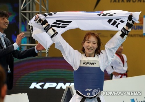 Sim Jae-young of South Korea lifts her national flag in celebration of her gold medal in the women's under-46kg at the World Taekwondo Federation (WTF) World Taekwondo Championships at Taekwondowon's T1 Arena in Muju, North Jeolla Province, on June 25, 2017. (Yonhap)