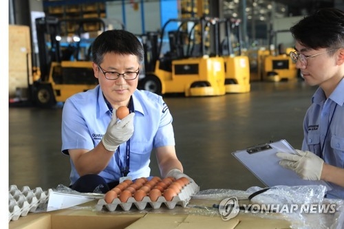 Quarantine officials inspect samples of eggs imported from Thailand at a freight terminal in Incheon International Airport, west of Seoul, upon their arrival on June 21, 2017. (Yonhap) 