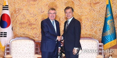 South Korea's President Moon Jae-in and International Olympic Committee Chief Thomas Bach shake hands at the South Korean presidential office Cheong Wa Dae in Seoul on July 3, 2017. (Yonhap)