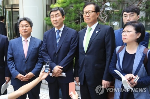Ex-Rep. Kang Ki-jung, incumbent Rep. Lee Jong-kul of the Democratic Party, former Reps. Moon Byung-ho and Kim Hyun (from L to R) speak to reporters after they are acquitted by a higher court of charges over the illegal detention of an intelligence agent, in Seoul on July 6, 2017. (Yonhap) 