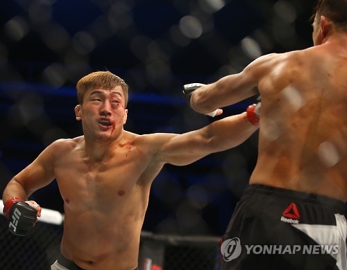 In this file photo taken on Nov. 28, 2015, South Korean mixed martial arts (MMA) fighter Bang Tae-hyun (L) lands a punch on Leo Kuntz of the United States during their lightweight bout at the UFC Fight Night 79 at Olympic Gymnastics Arena in Seoul. (Yonhap)