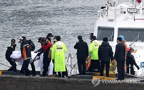 Coast Guard officials carry the body of a victim of the ill-fated chartered fishing boat accident that happened near Incheon on Dec. 3, 2017. (Yonhap)