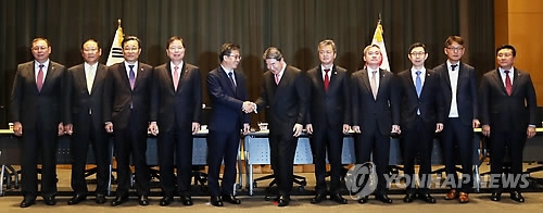 Finance Minister Kim Dong-yeon (5th from L) shakes hands with LG Group Chairman Koo Bon-moo in Seoul on Dec. 12, 2017. (Yonhap)