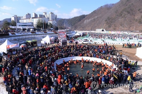 This 2017 file photo shows visitors catching "sancheoneo," a type of mountain trout, with their bare hands during the annual Hwacheon Sancheoneo Ice Festival in Hwacheon, 120 kilometers northeast of Seoul. (Yonhap)