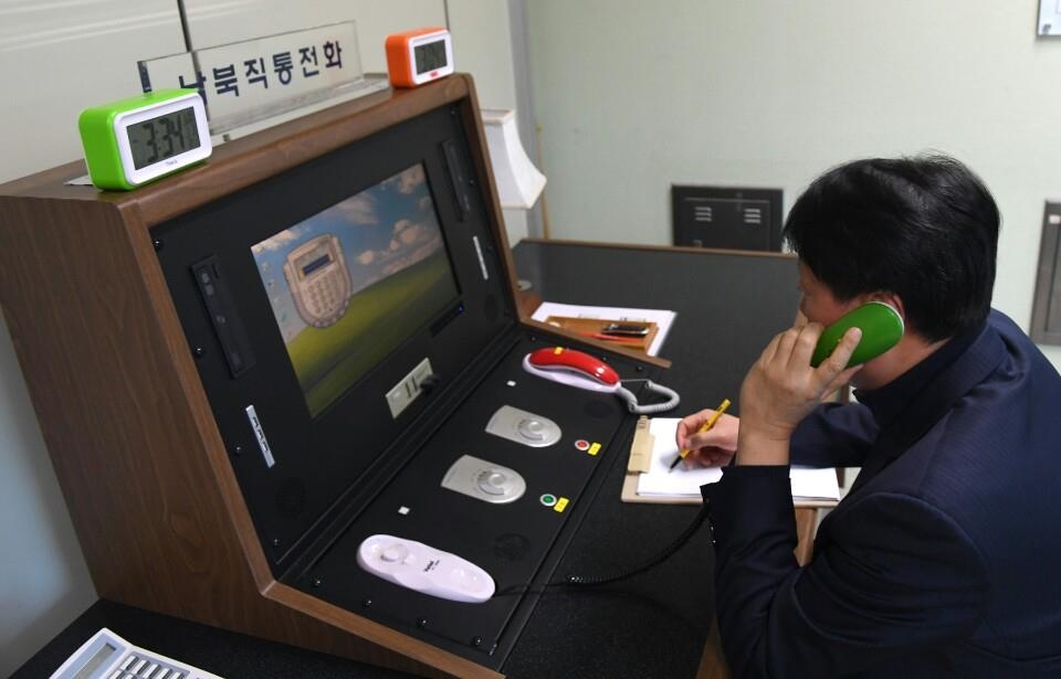 This photo, provided by South Korea's unification ministry, on Jan. 3, 2018, shows a South Korean liaison official contacting his North Korean counterpart via the restored cross-border communication channel. (Yonhap)