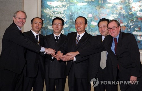 This file photo, taken Sept. 19, 2005, shows the top nuclear envoys of the two Koreas, the United States, China, Russia and Japan posing for a photo in Beijing. (Yonhap)