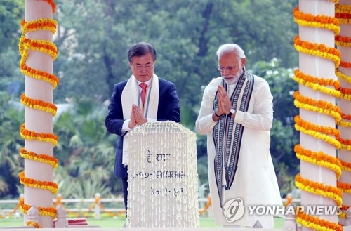 South Korean President Moon Jae-in (L) and Indian Prime Minister Narendra Modi pray in front of the monument commemorating the late Indian activist and leader Mahatma Gandhi during their joint visit to the National Gandhi Museum in New Delhi on July 9, 2018. (Yonhap)