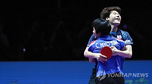 Cha Hyo-sim of North Korea (foreground) and Jang Woo-jin of South Korea embrace after winning the gold medal in the mixed doubles at the International Table Tennis Federation (ITTF) World Tour Platinum Korea Open at Chungmu Sports Arena in Daejeon, 160 kilometers south of Seoul, on July 21, 2018. (Yonhap)