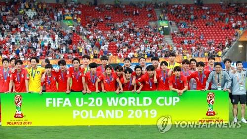 South Korean players and coaches pose for photos behind the banner for the FIFA U-20 World Cup after losing to Ukraine 3-1 in the final at Lodz Stadium in Lodz, Poland, on June 15, 2019. (Yonhap)