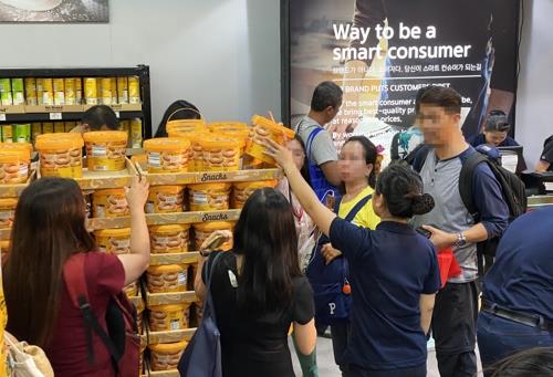This undated photo, provided by E-Mart Inc., shows people shopping for one of the company's private-label (PB) snacks, at its outlet in Manila. (PHOTO NOT FOR SALE) (Yonhap)