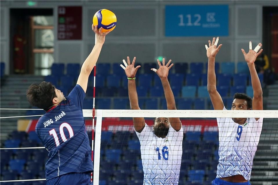 In this photo provided by FIVB on Jan. 8, 2020, Jung Ji-seok of South Korea (L) tries to hit a spike past Mohan Ukkrapandian (C) and Deepesh Kumar Sinha of India in their Pool B match of the Asian Olympic men's volleyball qualification tournament at Jiangmen Sports Center Gymnasium in Jiangmen, China. (PHOTO NOT FOR SALE) (Yonhap)