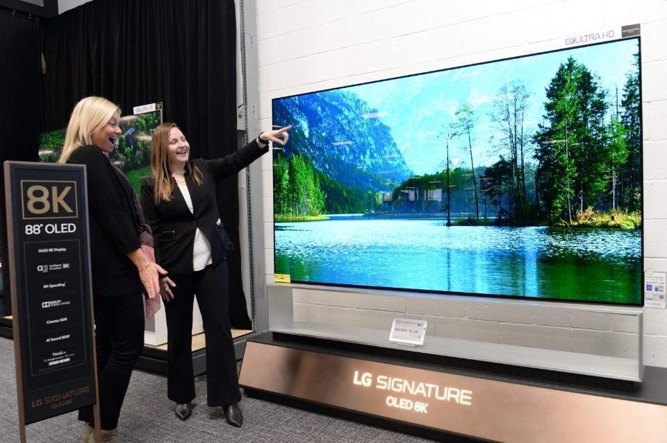 This photo provided by LG Electronics Inc. on Jan. 9, 2020, shows a LG employee explaining the company's 88-inch 8K OLED TV to a customer at a Best Buy store in Las Vegas, Nevada. (PHOTO NOT FOR SALE) (Yonhap)
