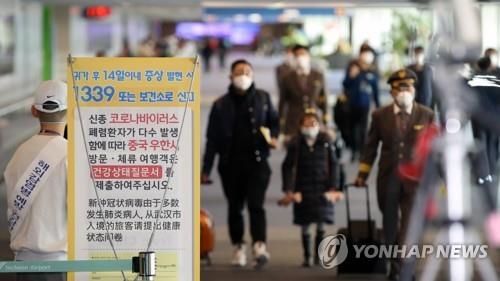 Passengers and airline crew members wearing masks approach a quarantine checkpoint at Incheon International Airport, west of Seoul, on Jan. 28, 2020, in this file photo. (Yonhap)