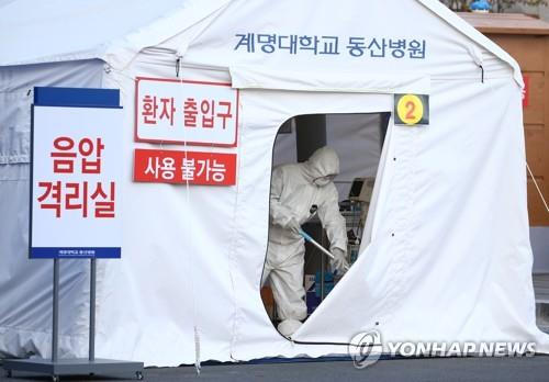 Workers erect a temporary negative-pressure quarantine room outside a hospital in Daegu, 300 kilometers southeast of Seoul, on Feb. 21, 2020, to accommodate suspected coronavirus patients waiting for their test results. (Yonhap)