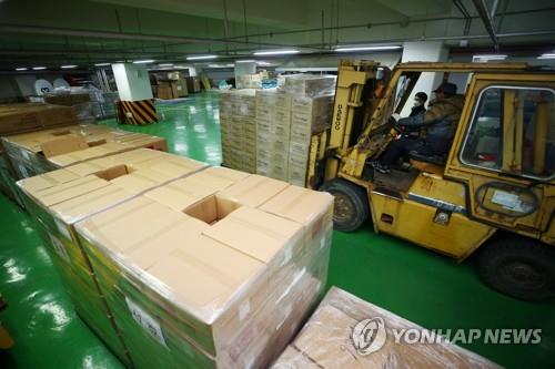 Workers stack a variety of emergency relief goods pouring in from all over the country at Daegu Stadium in COVID-19-hit Daegu, 300 kilometers southeast of Seoul, on Feb. 28, 2020. (Yonhap) 