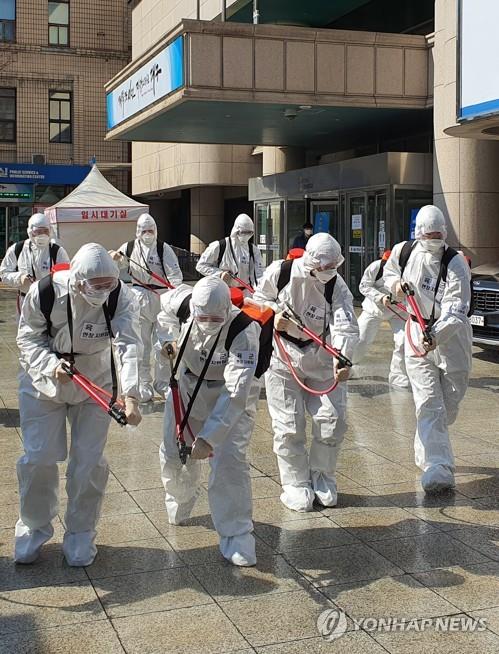 Soldiers disinfect the ground outside City Hall in the southeastern city of Daegu, the epicenter of the coronavirus outbreak in South Korea, on March 2, 2020. (Yonhap)