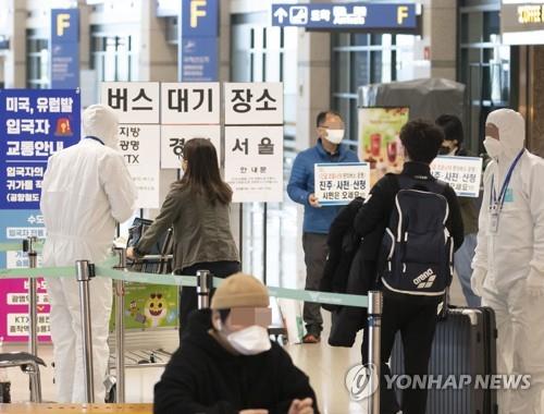 Entrants at South Korea's main gateway, Incheon International Airport, wait for a bus that will carry them to their respective houses on March 30, 2020. Starting on April 1, the country will enforce a two-week mandatory quarantine on all entrants from overseas in a drastic move to curb a steady rise in imported cases of COVID-19. (Yonhap)