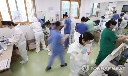 Medical workers at Dongsan Hospital in Daegu, 300 kilometers southeast of Seoul, put on protective gear as they get ready to treat novel coronavirus patients on April 9, 2020. (Yonhap) 