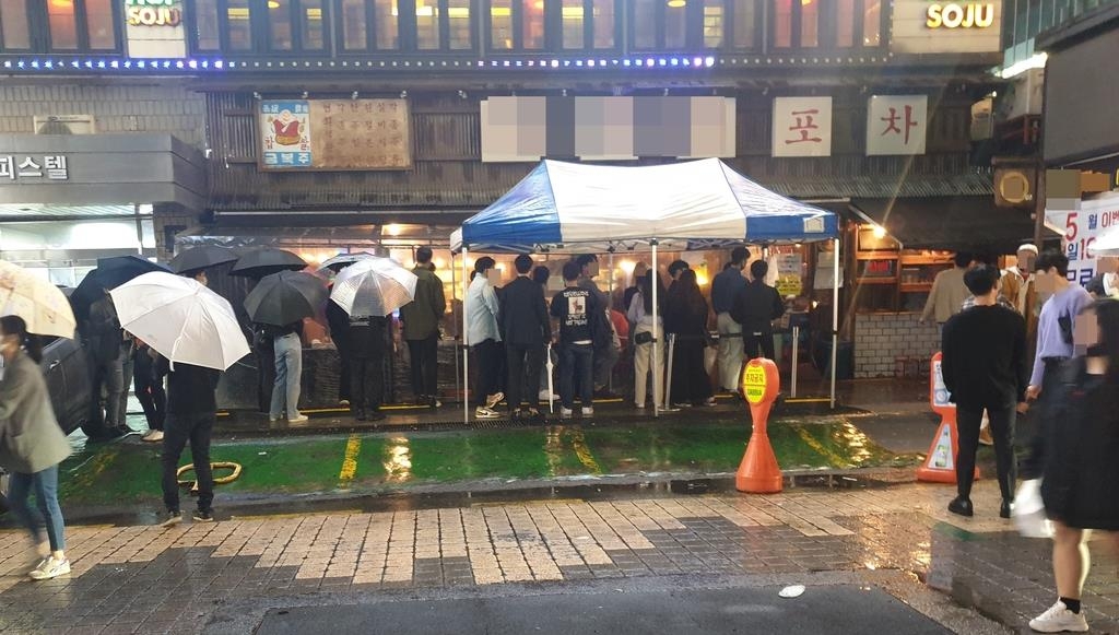 Customers form a long queue in front of a "pocha," a Korean-style bar, in the Gangnam district in southern Seoul, on May 9, 2020, despite concerns over the new coronavirus. (Yonhap) 