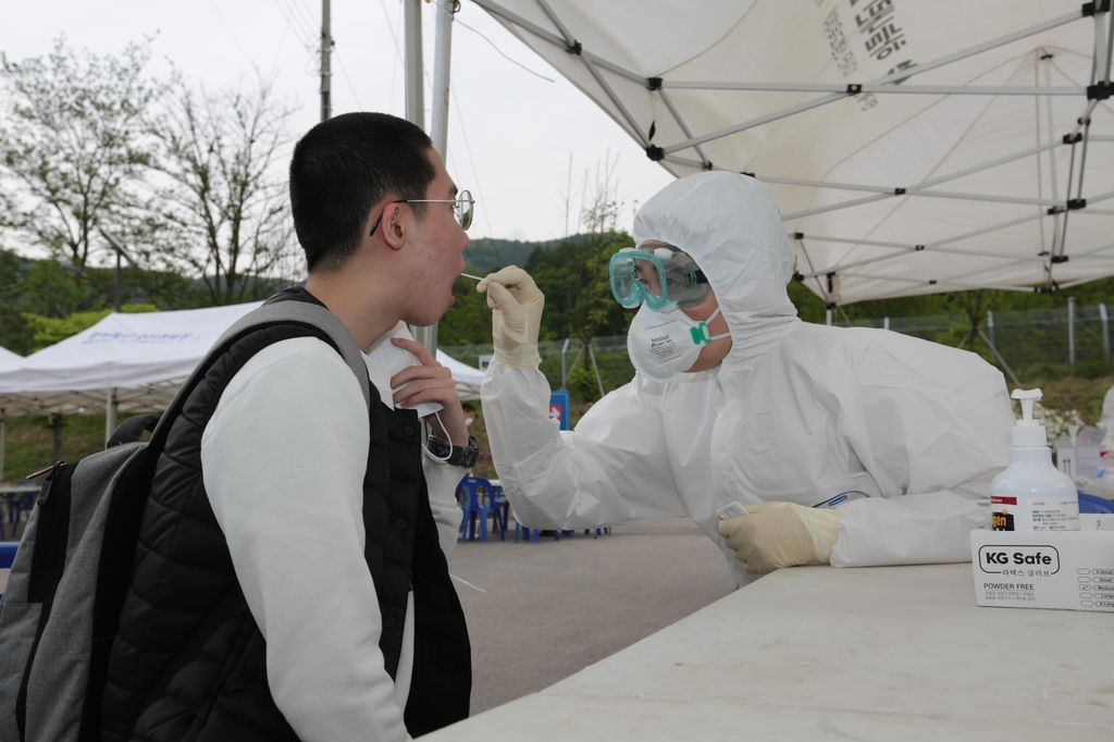 A medical official collects a sample from an enlistee for a coronavirus test upon his joining of the military at the Army's First Division boot camp in Paju, Gyeonggi Province, on May 18, 2020, in this photo provided by the Army. (PHOTO NOT FOR SALE) (Yonhap) 