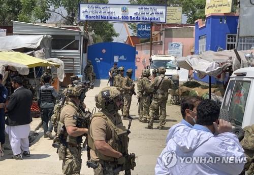 This AP photo shows Afghan security forces guarding the area near a hospital after an attack by armed forces in Kabul on May 12, 2020. (Yonhap) 