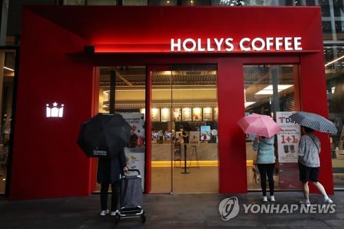 Pedestrians walk in front of a coffee shop in southern Seoul on Aug. 3, 2020, where at least 10 COVID-19 patients have been confirmed to have been infected. (Yonhap)