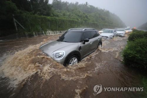 Cars are stranded along a flooded road in Jeju as Typhoon Maysak hit the resort island on Sept. 2, 2020 on course to the Korean Peninsula. (Yonhap)